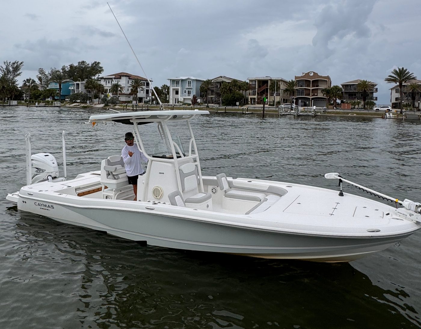 Hammer Down Sportfishing's 28' Caymas center-console on calm water, the waterfront homes behind
